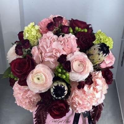 Pink and burgundy bouquet in a pink box with ribbon