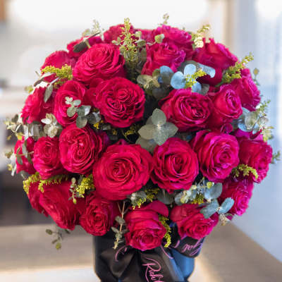 Bouquet of hot pink roses in a black hatbox