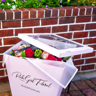 Pink gift box with roses and greenery inside