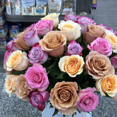 Bouquet of pink, peach, and lavender roses in a white hat box