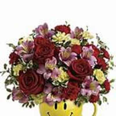 Mixed flower bouquet in a yellow smiley-face mug