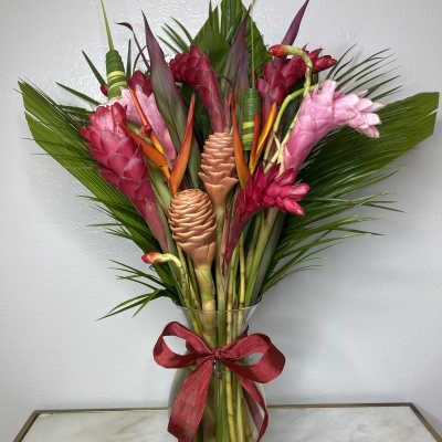 Tropical bouquet with pink and red ginger flowers in a glass vase