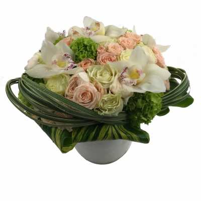 Bouquet of pale roses and white orchids in a round vase
