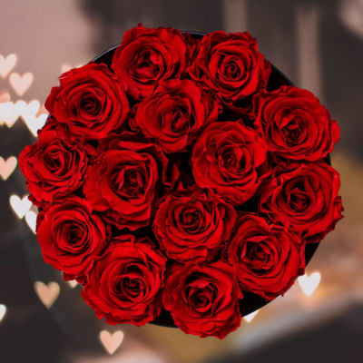 Round bouquet of red roses in a black container