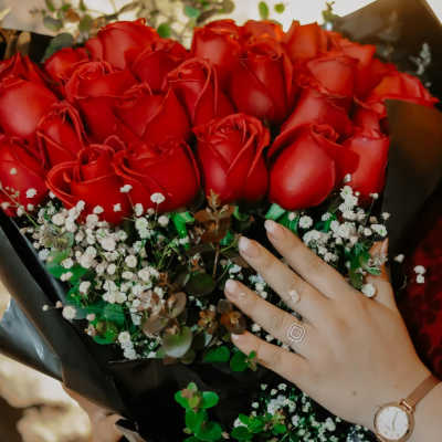 Bouquet of red roses with baby's breath in black wrap