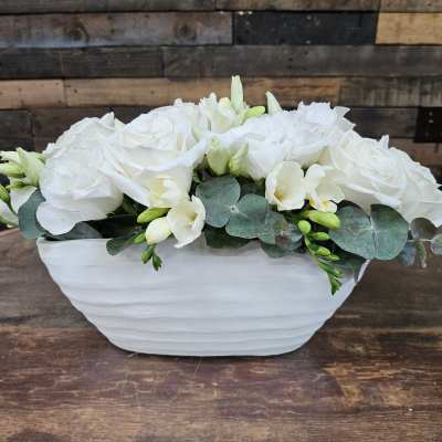White roses and pale flowers in a white ceramic bowl