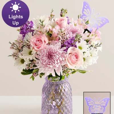 Pink and white mixed bouquet in a purple textured vase with a butterfly topper