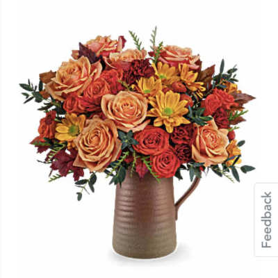 Bouquet of orange and red roses with yellow daisies in a brown vase