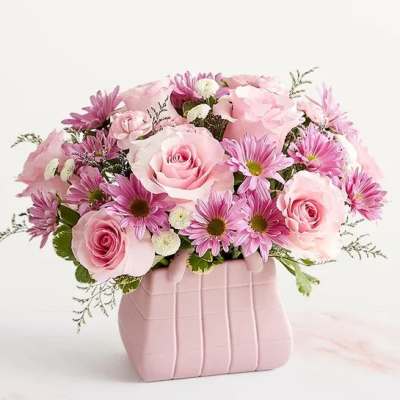 Pink roses and daisies arranged in a pink vase