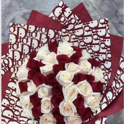 Bouquet of red and white roses wrapped in patterned paper