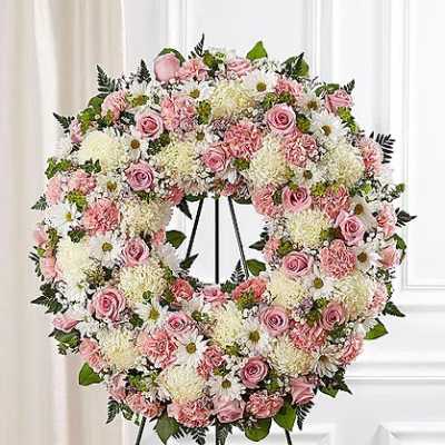 Pink and white floral wreath on a black easel