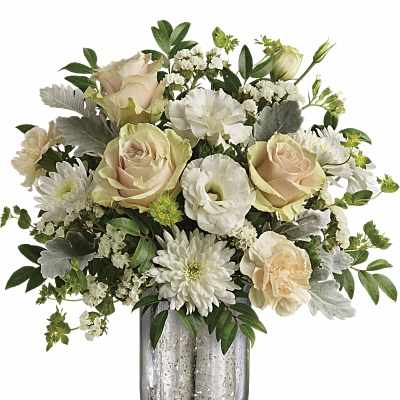 Cream roses and white blooms arranged in a silver glass vase