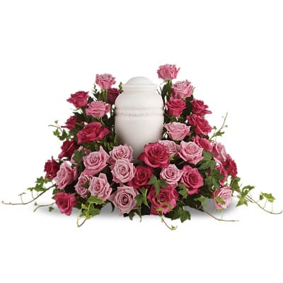 Pink and magenta roses arranged around a white urn