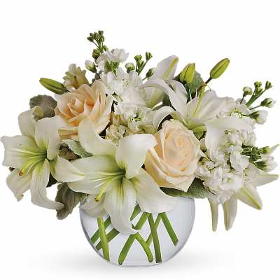 White lilies and pale roses in a round glass vase