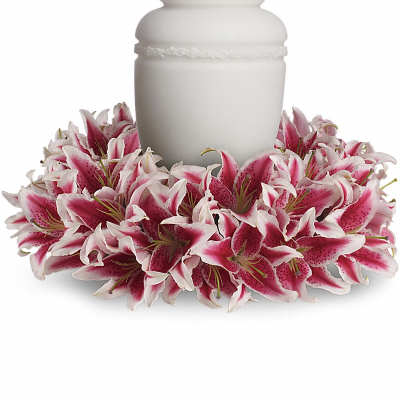 White urn surrounded by pink lilies
