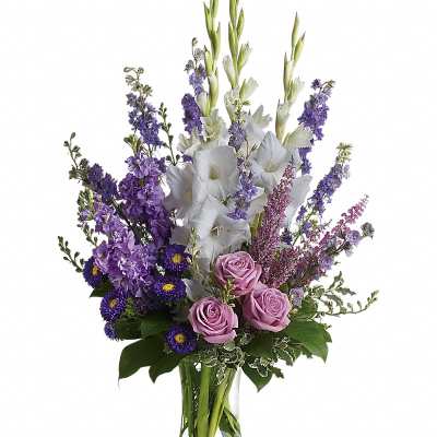 Purple and white floral arrangement in a clear glass vase