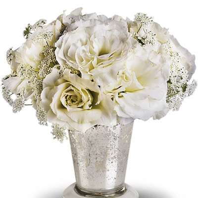 White roses in a silver vase with delicate filler flowers