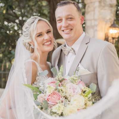 Bride and groom holding a pastel rose bouquet