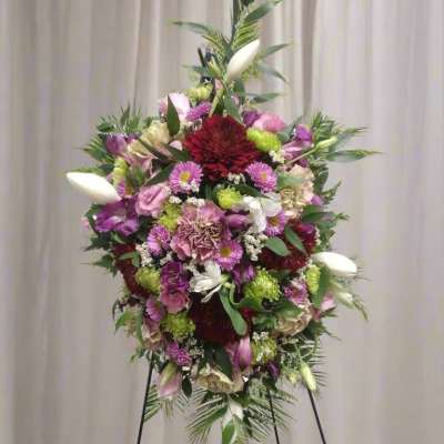Large standing floral spray with pink, purple, white, and red blooms