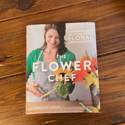 A floral arrangement guide book on a wooden table