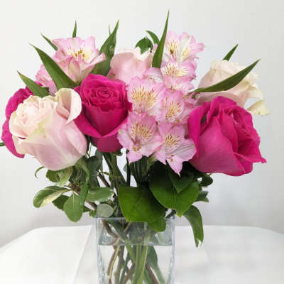 Pink and white roses with alstroemeria in a clear glass vase