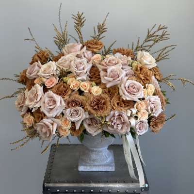 Large bouquet of blush and tan roses in a gray vase