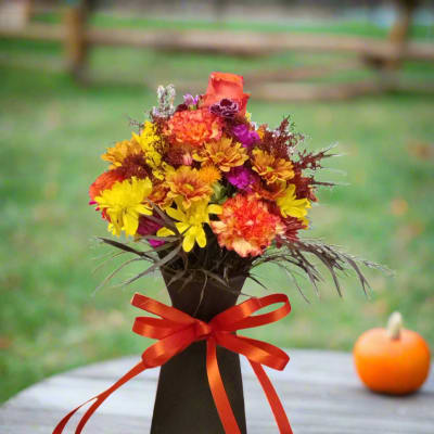 Autumn bouquet in a black vase with a red ribbon