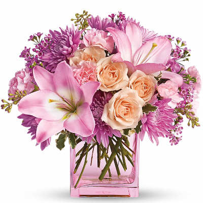Pink and peach bouquet in a pink glass vase