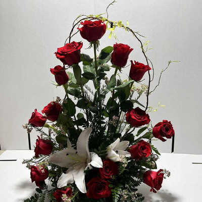 Tall arrangement of red roses and white lilies on a table