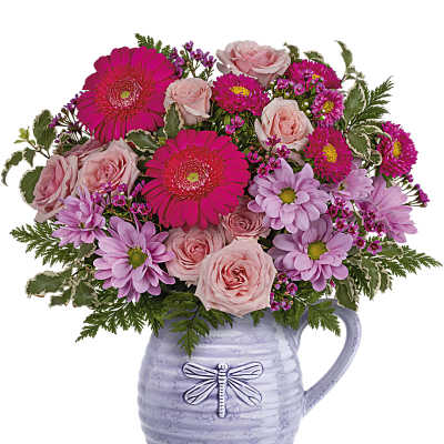 Pink roses and daisies arranged in a lavender pitcher vase