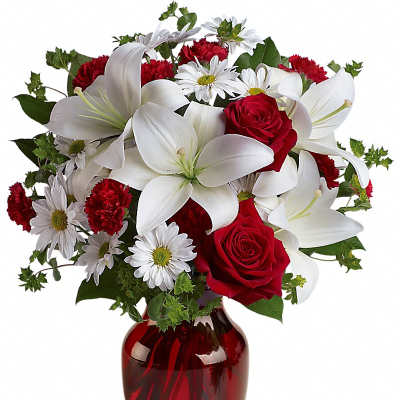 Red roses and white lilies in a red glass vase