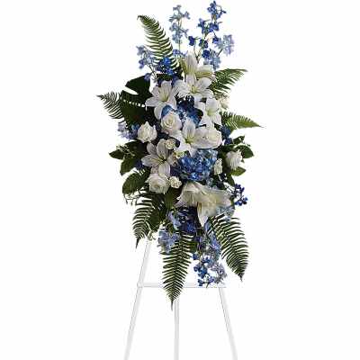 White lilies and blue flowers on a standing easel spray