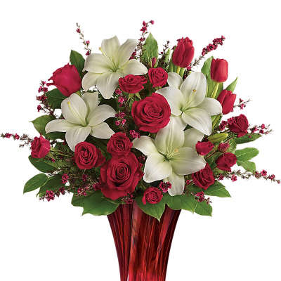 Red roses and white lilies in a red glass vase