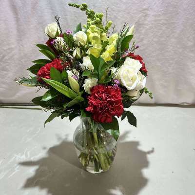 Bouquet of red and white flowers in a clear glass vase