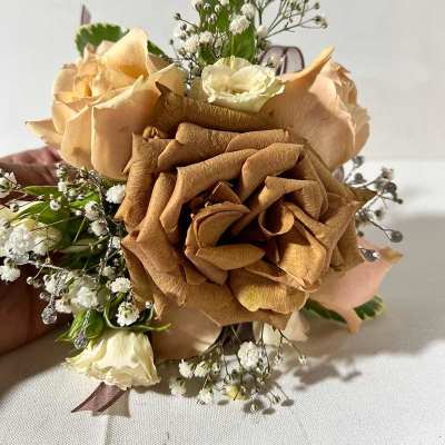 Hand-tied bouquet of tan and cream roses with baby's breath