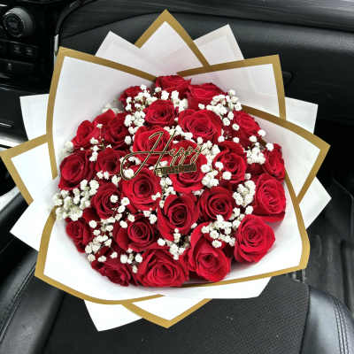 Bouquet of red roses with white baby's breath and a birthday topper