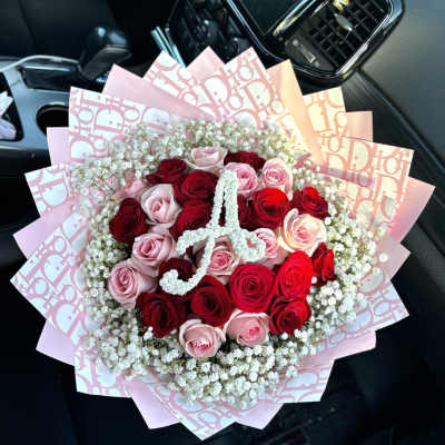Bouquet of red and pink roses with baby's breath in pink wrapping