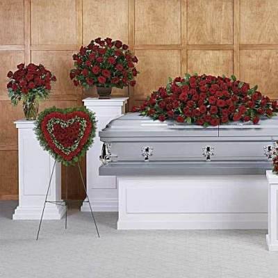 Red rose funeral casket spray with standing floral tributes