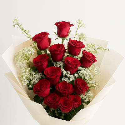 Bouquet of red roses wrapped in cream paper with a red ribbon