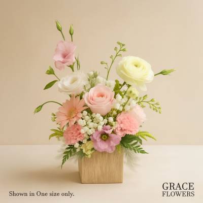 Pastel floral arrangement in a square wooden vase