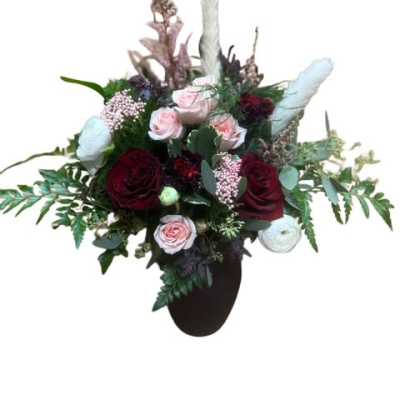Mixed bouquet with red and pale pink roses in a dark vase