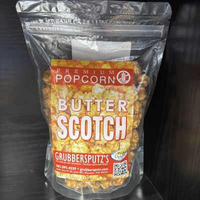 Clear bag of butter scotch popcorn on a dark shelf