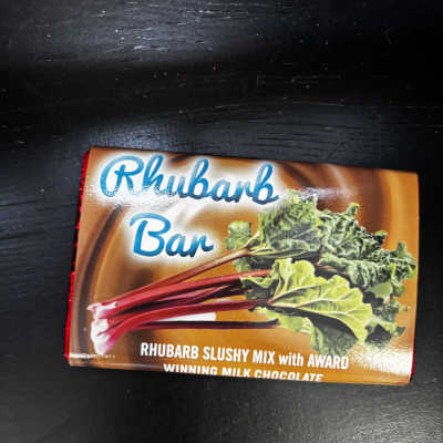 A Rhubarb Bar chocolate package on a dark surface