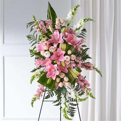 Tall standing floral spray with pink lilies and roses on an easel