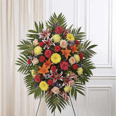 Large standing floral spray with mixed roses, lilies, and daisies