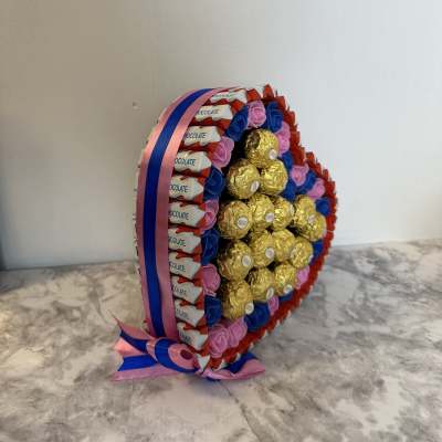 Heart-shaped candy arrangement with chocolate bars and gold-wrapped chocolates