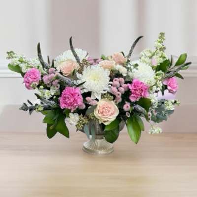 Pink and white floral arrangement in a silver vase