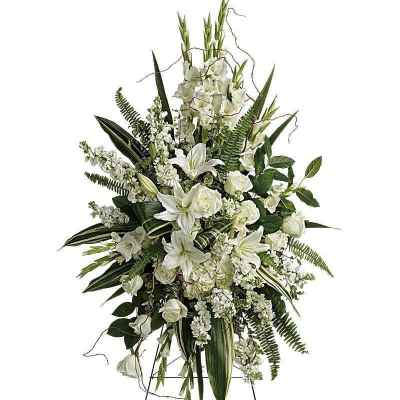 White floral standing spray with lilies and roses on a metal easel