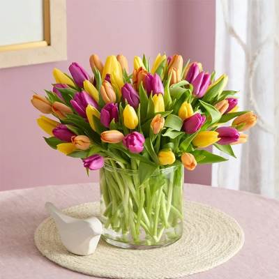 Bouquet of multicolored tulips in a clear glass vase