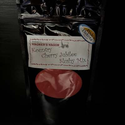 Black pouch of cherry jubilee slushy mix with a red fruit graphic